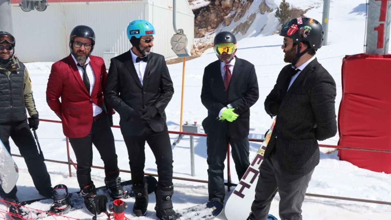 Takım elbise, kravat ve papyonla snowboard keyfi yaptılar