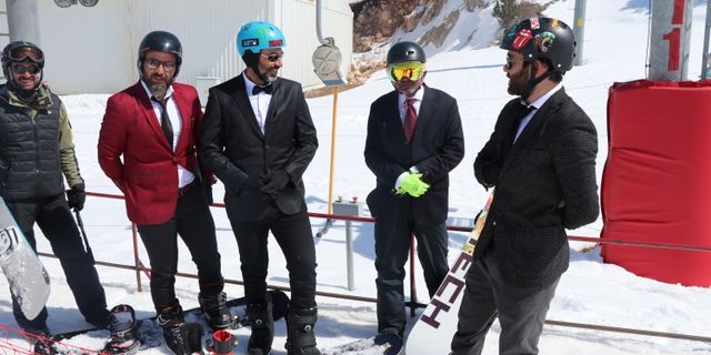 Takım elbise, kravat ve papyonla snowboard keyfi yaptılar